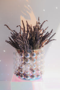 Iridescent vase with dried lavender on a light background