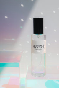 Lavender Provence room spray in a glass container with a black lid on a iridescent background.
