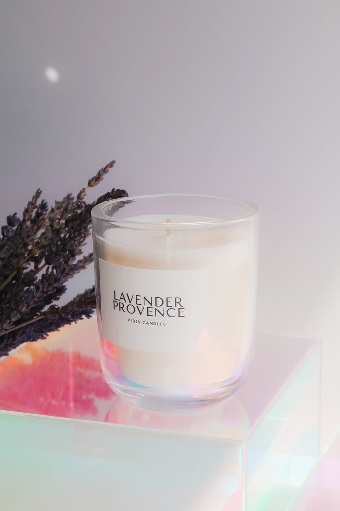 Candle labeled 'Lavender Provence' with lavender flowers on a colorful surface